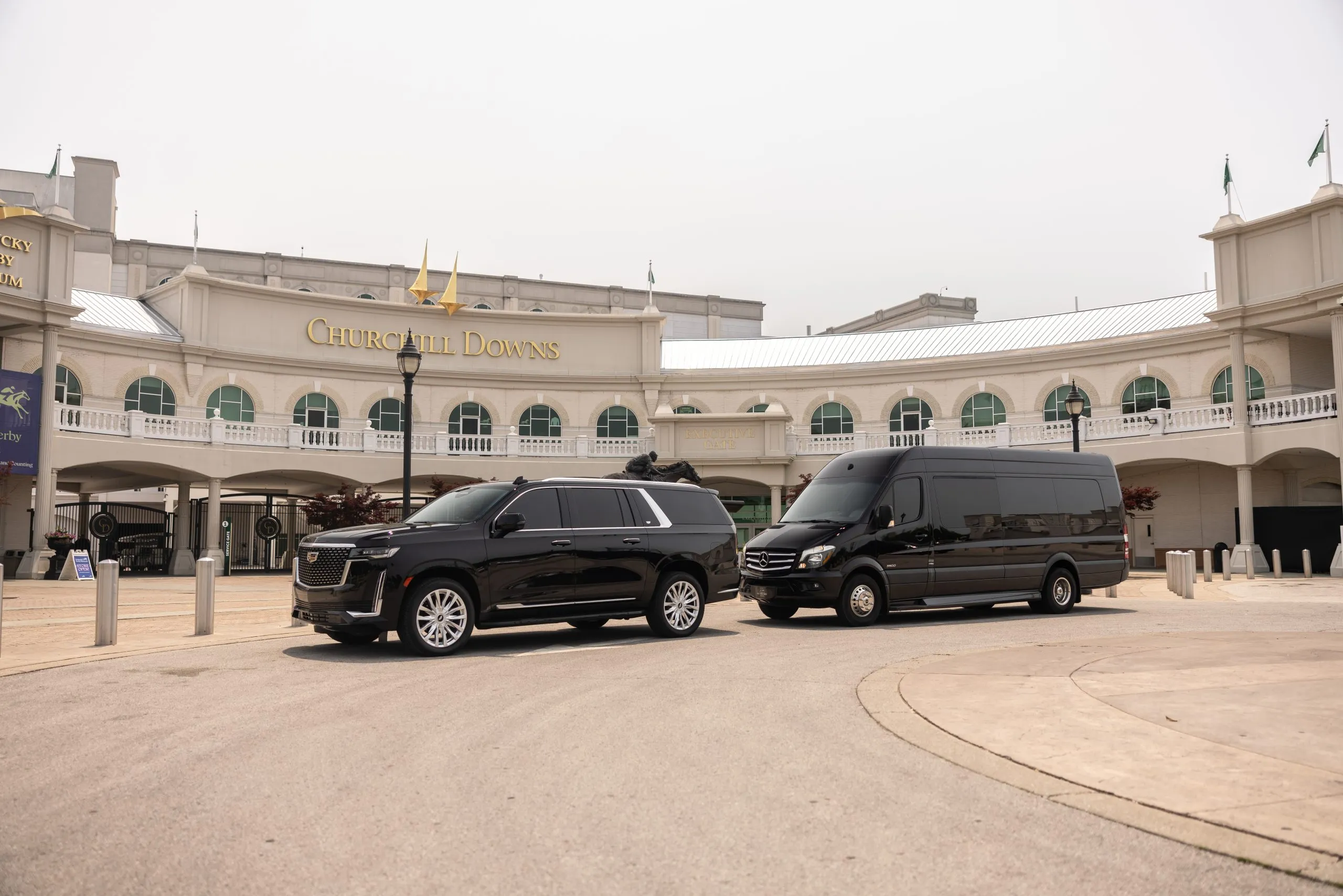 Cadillac Escalade ESV and Mercedes Sprinter parked at the Churchill Downs gates