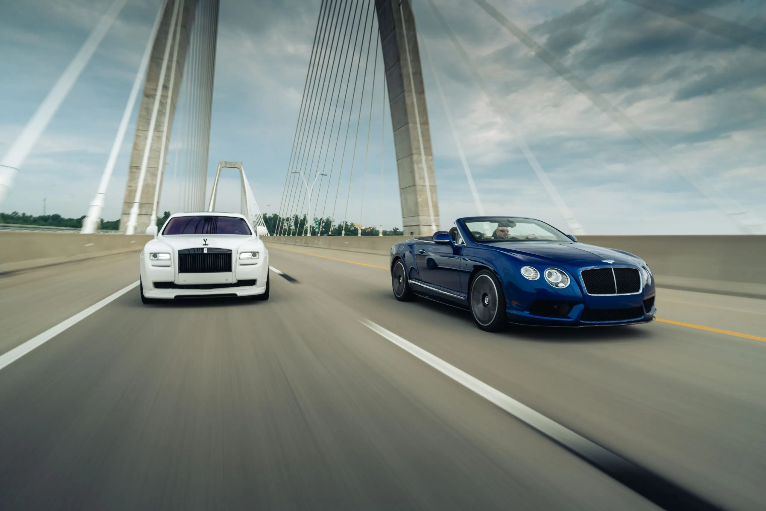 Rolls-Royce Ghost and Bentley Continental GTC crossing a Louisville bridge