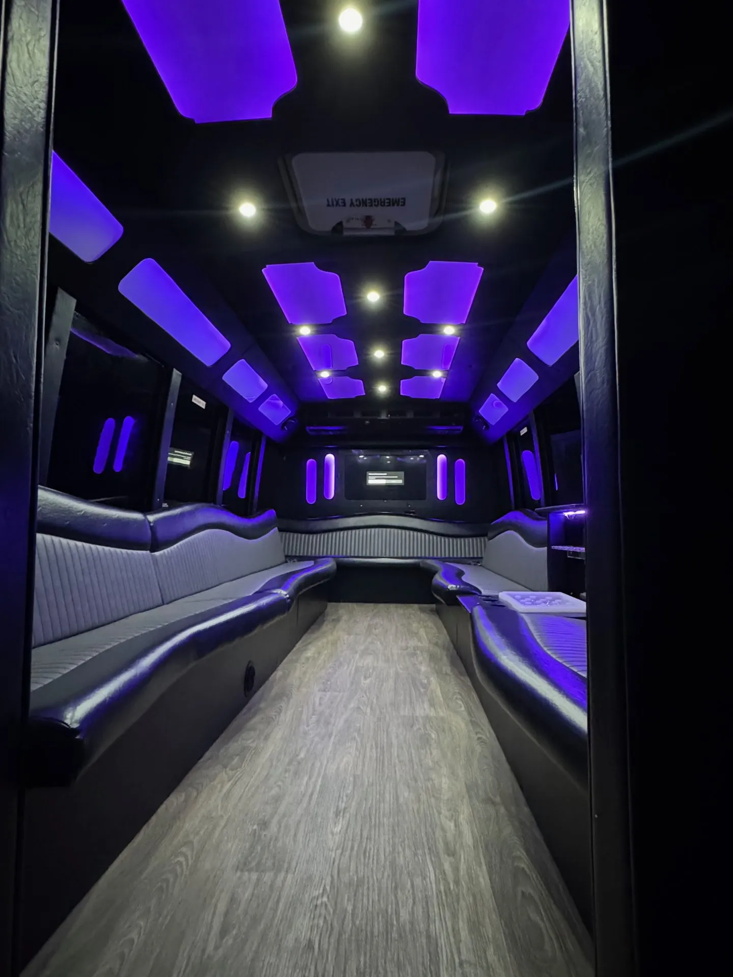 Inside the Mercedes Sprinter party bus with purple LED lighting and wraparound seating
